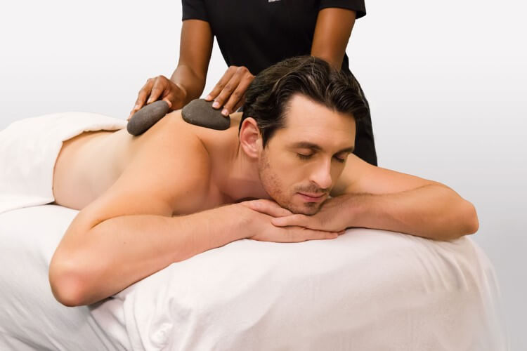 Two hot stones being used soothingly to perform a massage.